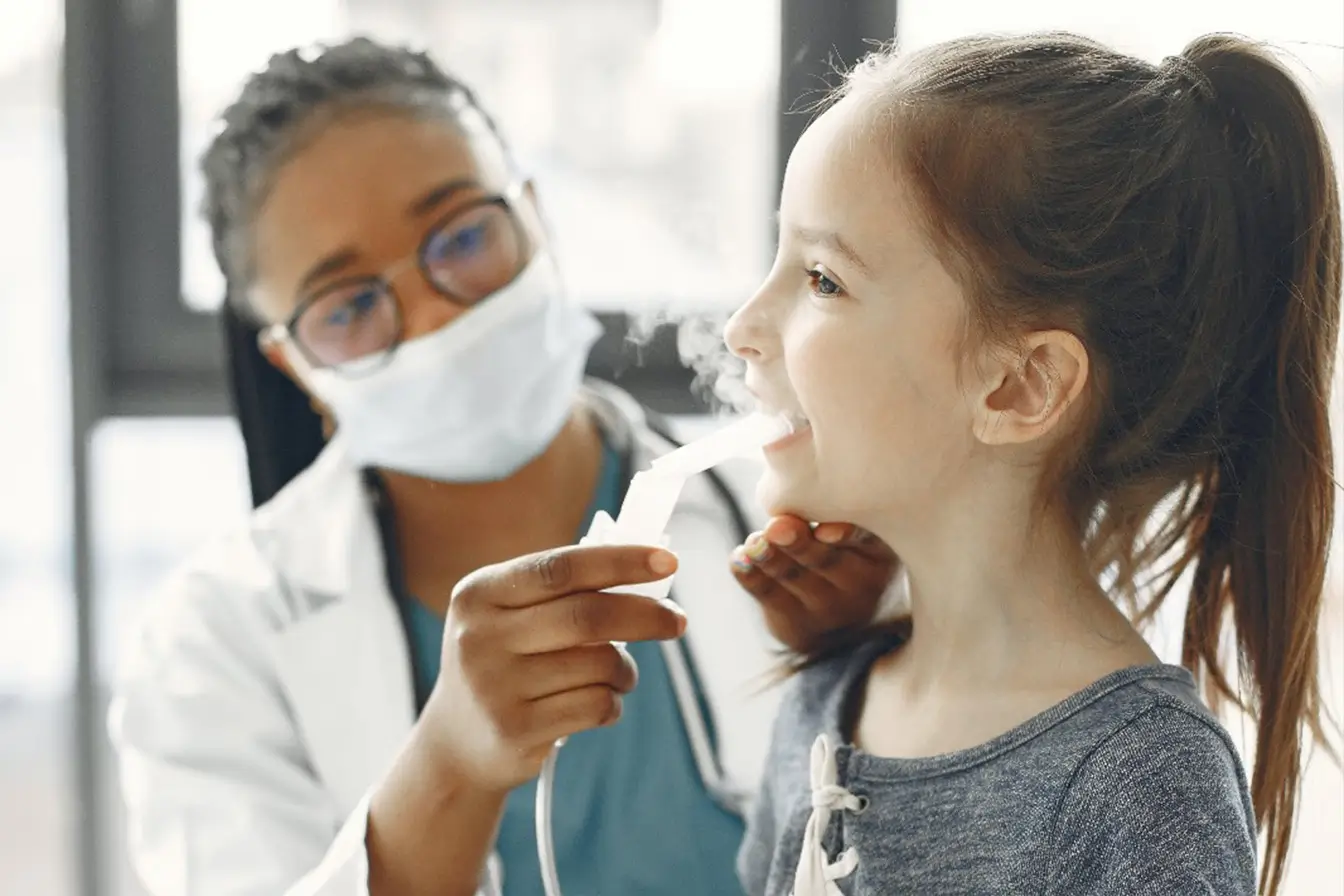 A woman administers a nebulizer to a girl